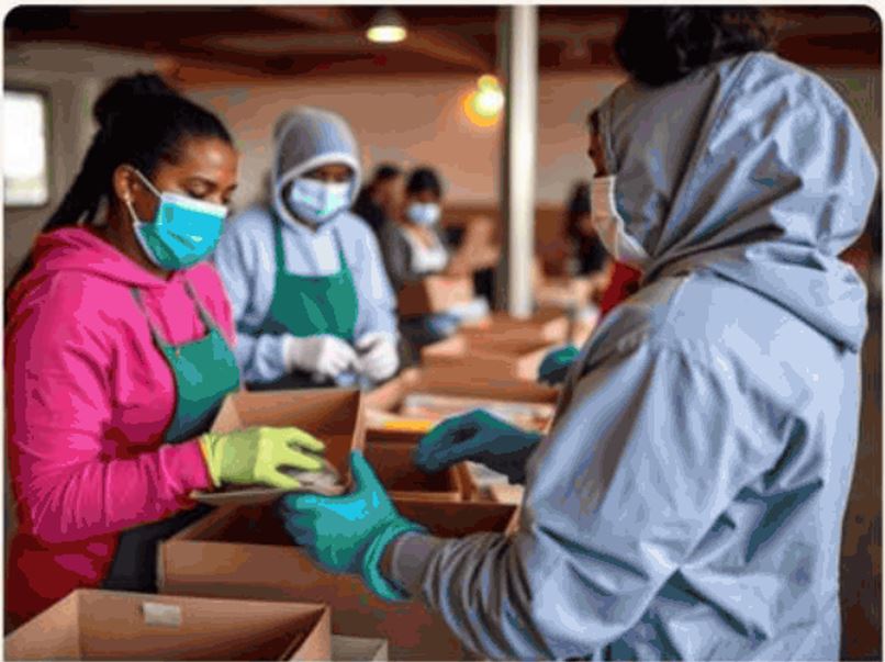 Masked volunteers in gloves and aprons packing relief supply boxes for patients and families